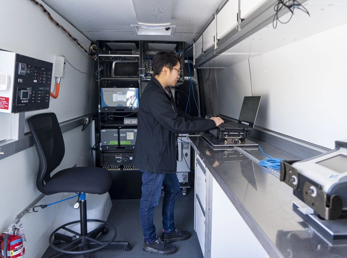 Air quality technician inside mobile air monitoring lab