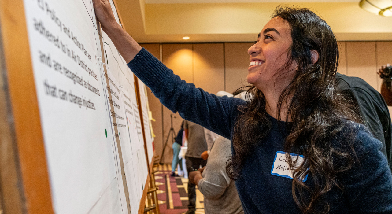 Woman smiling while engaging with a whiteboard