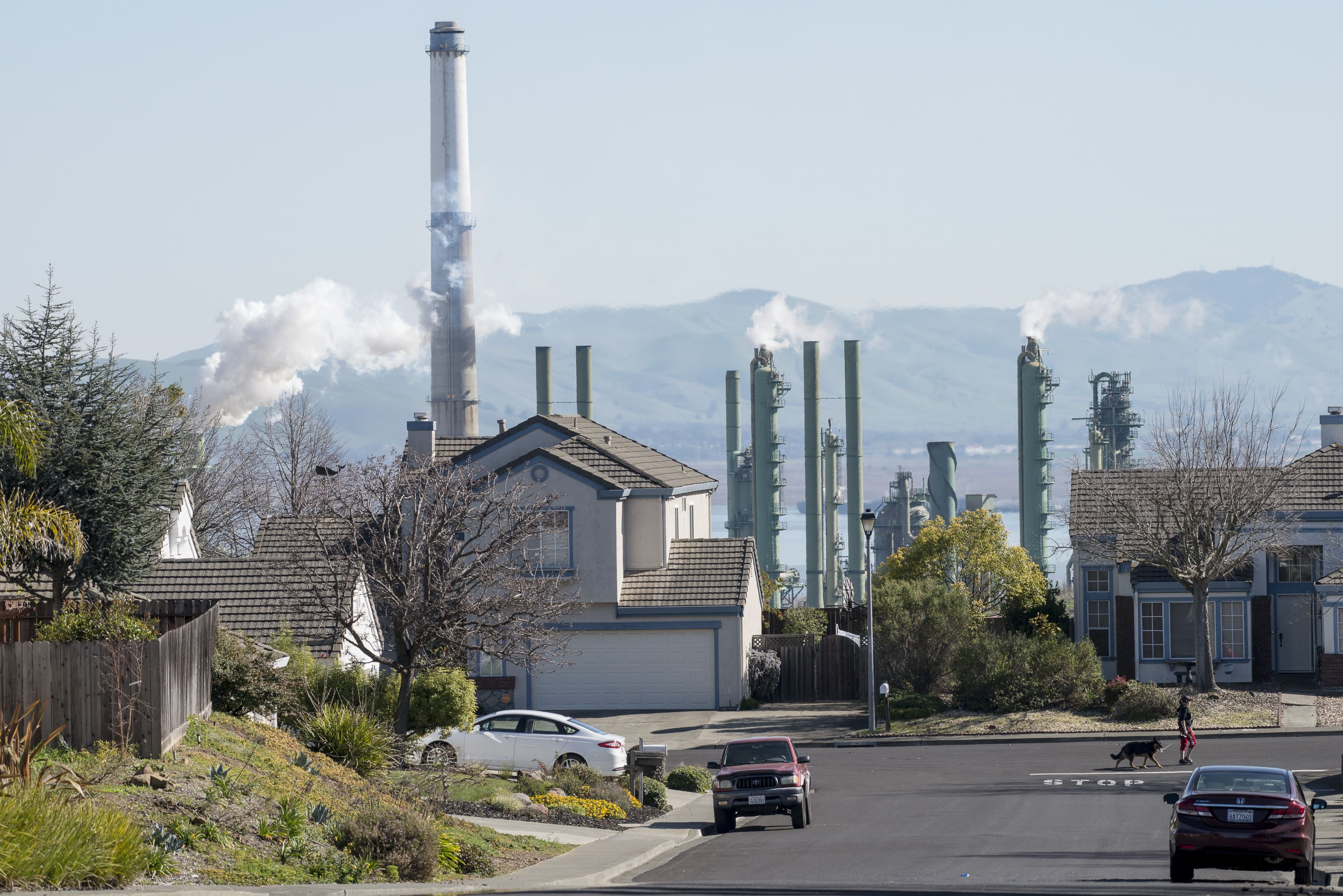 Residential street with fog from power plant chimneys in the background