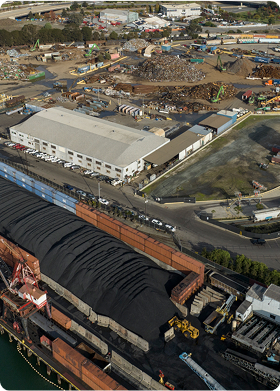 Workers at a seaport involved in environmental cleanup around muddy shore